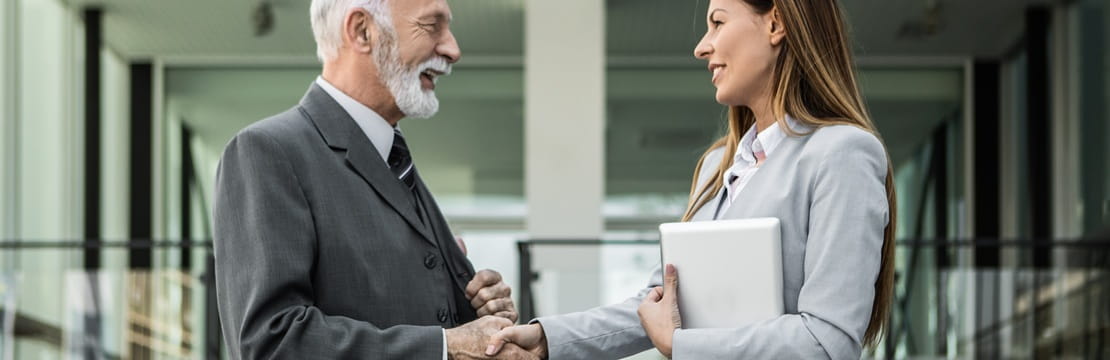 Business owner shaking hands with an advisor, representing planning an estate plan to protect and transfer a business.